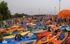 Colorful docked paddleboats with crowds on shore