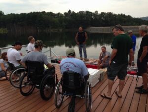 Men in wheelchairs at kayak launch