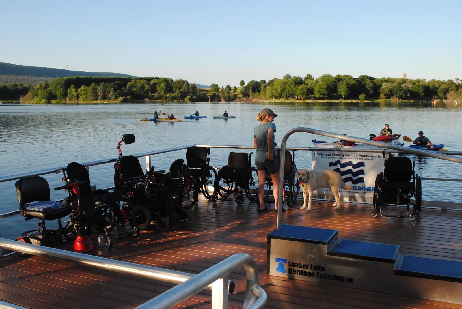 Wheelchairs on BoardSafe dock with kayakers on water