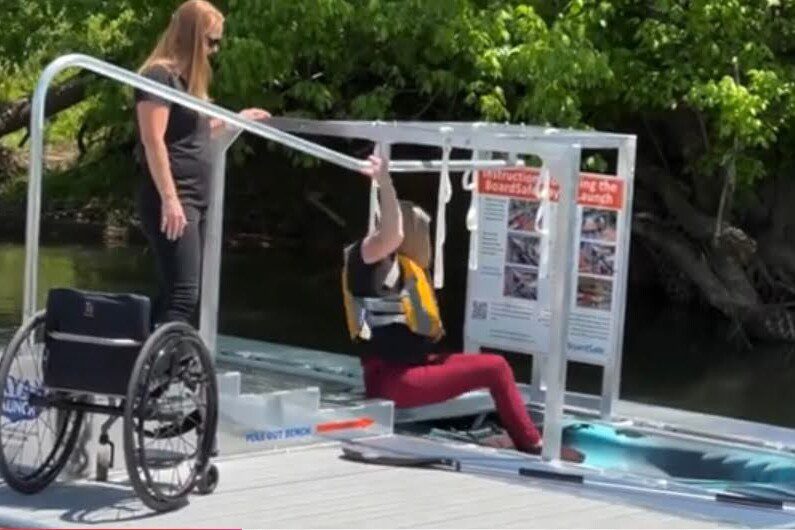 Woman entering kayak from BoardSafe accessible launch